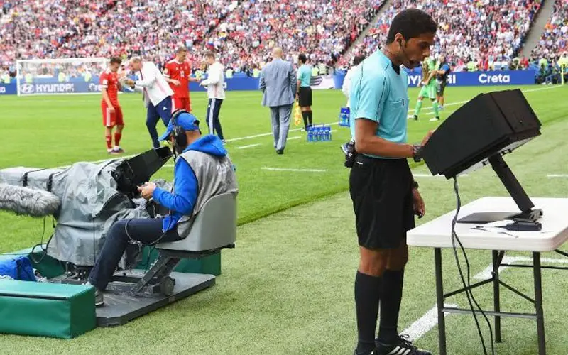 soccer referee checking var screen